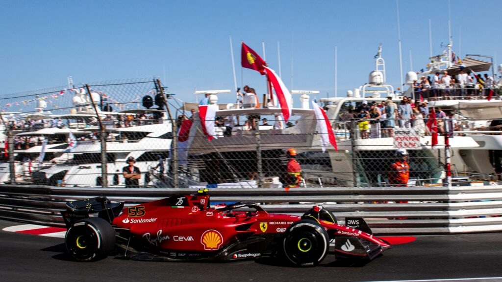 A Ferrari Formula 1 car racing past a line up of super yachts in Monaco Marina — Monaco Formula 1