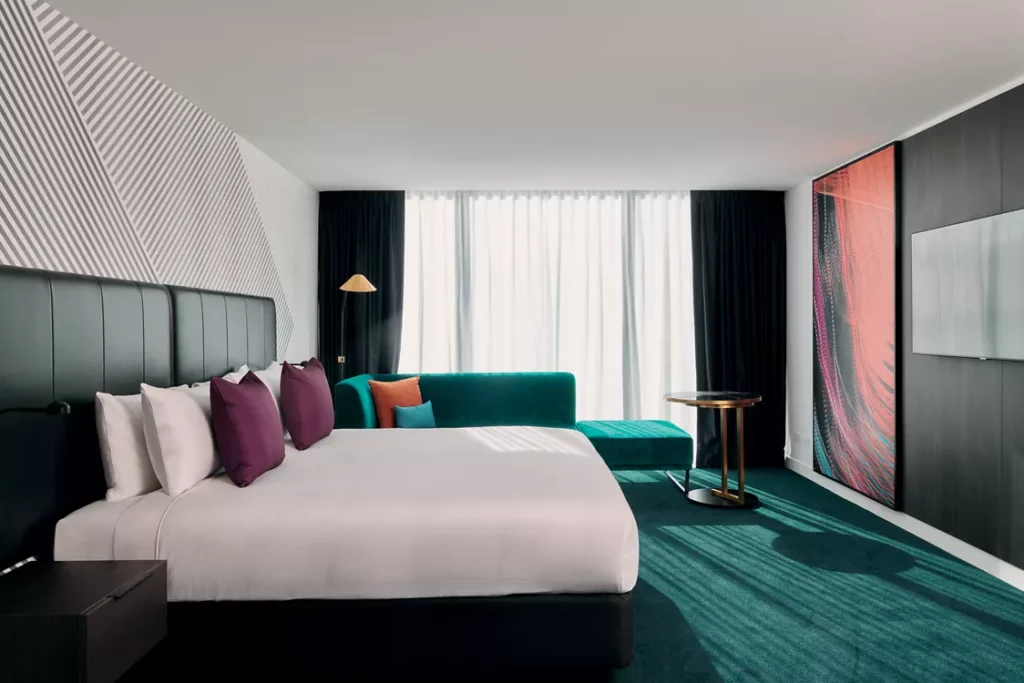 A mainly neutral room at the Mövenpick Hotel Melbourne, with statement green carpet and purple cushions.

Luxury Hotels in Melbourne